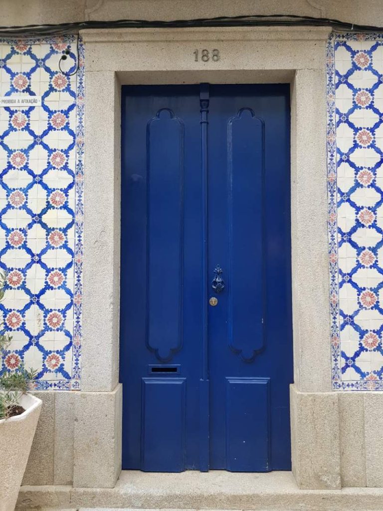 blaue, portugiesische, originale Tür und Hauswand mit Fliesenmuster