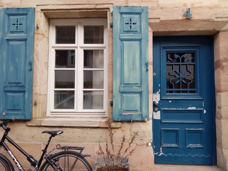 eine Hausfront mit alter blauer Tür und blauen Fensterläden in Erlangen