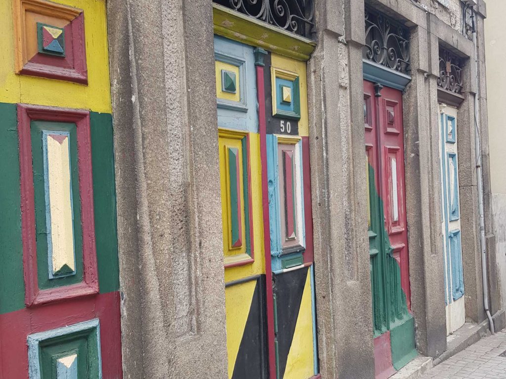 eine Hausfront mit sehr alten, bunten gestrichenen Haustüren