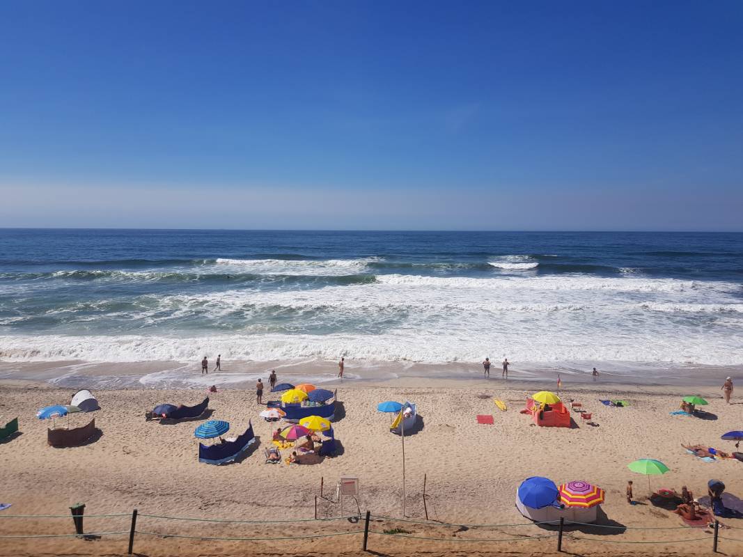 Strand mit vielen bunten Sonnenschirmen
